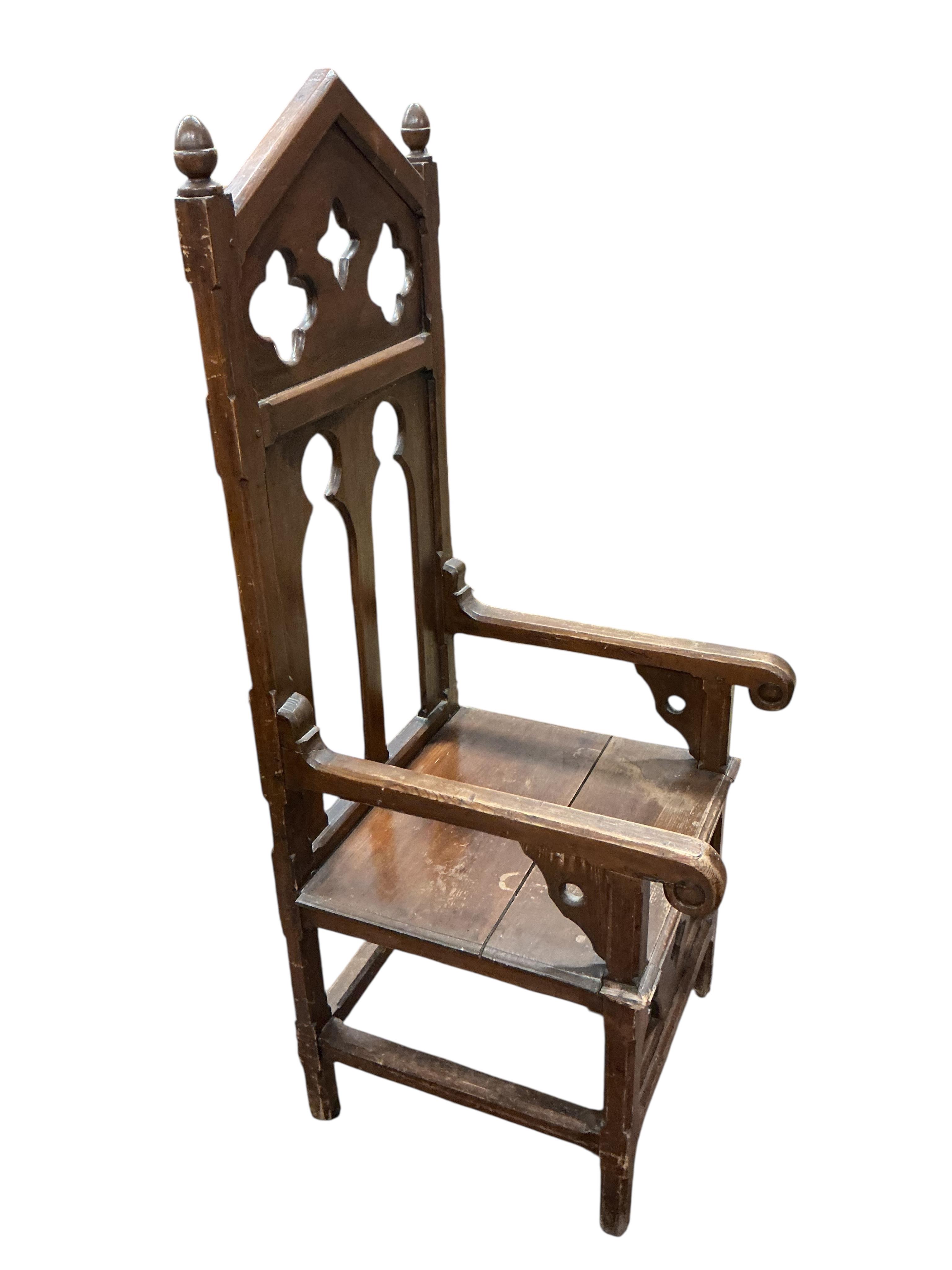 A pair of Gothic style ecclesiastical pine high back elbow chairs, width 52cm, depth 60cm, height 143cm